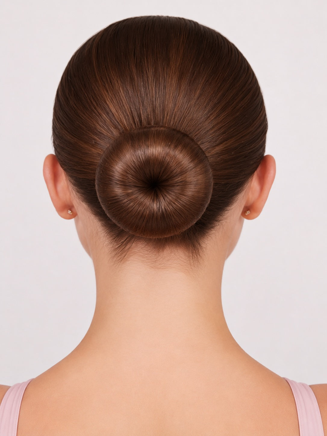 Finished smooth ballet bun created using a ballet bun doughnut hair accessory on brunette hair