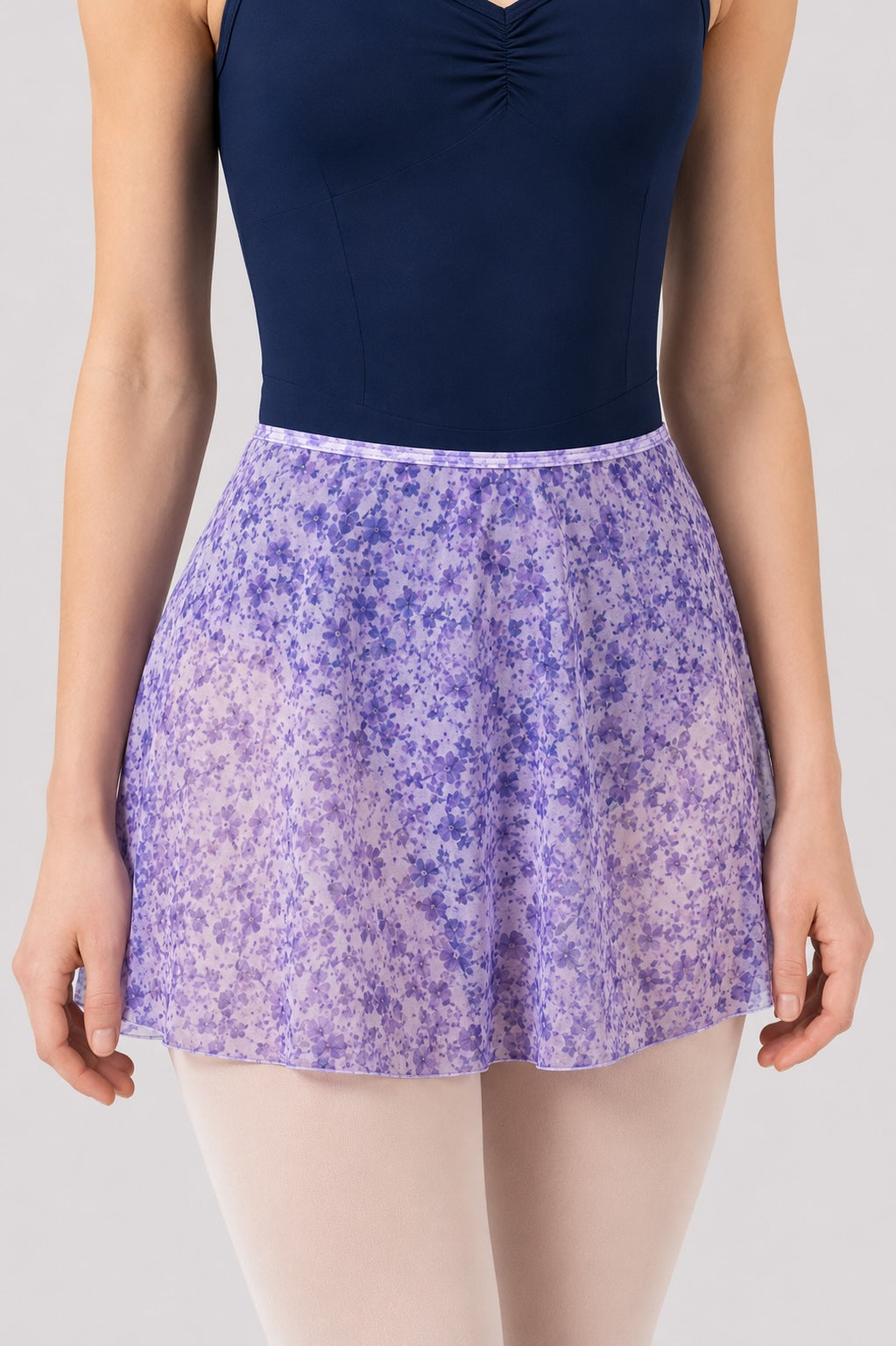 Close-up of Bloch R0241 Lilac Haze floral ballet skirt worn with navy ballet leotard