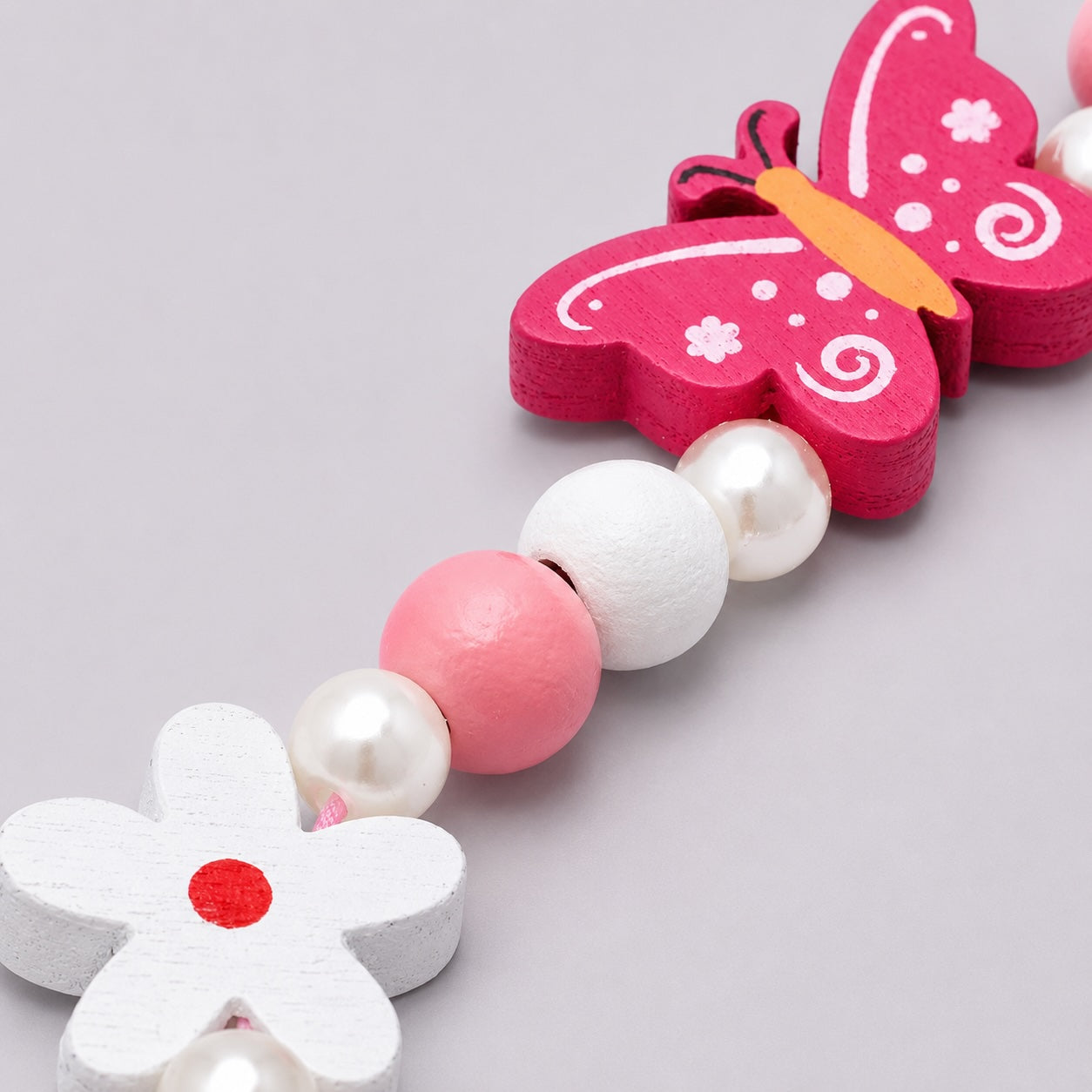“Close-up of pink butterfly charm beaded jewellery set for children”