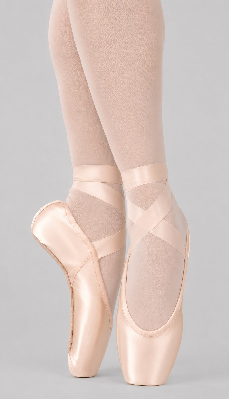Front view of Capezio Ava Pointe Shoes 1141W in petal pink satin with ballet tights showing the platform and broad toe box