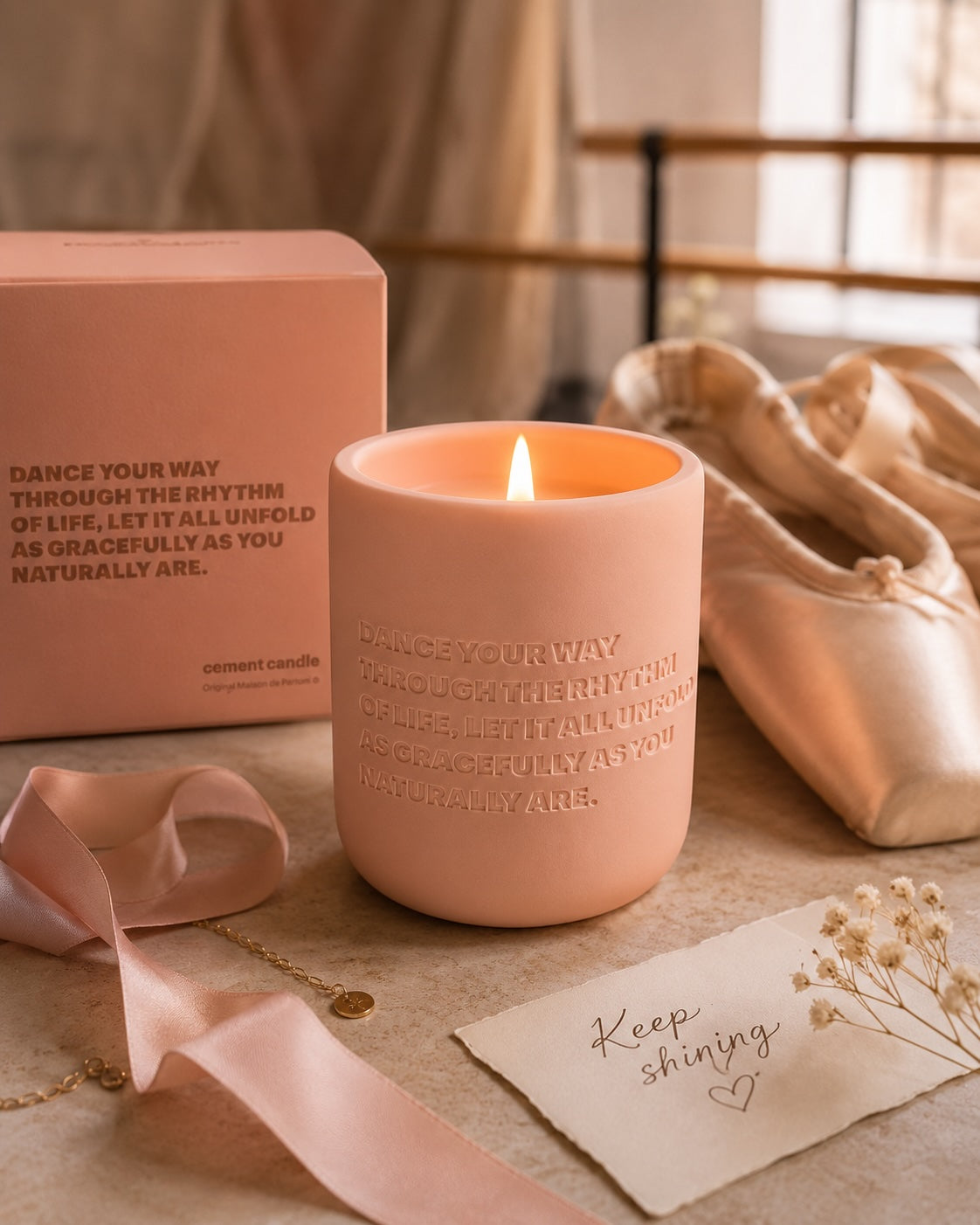 Luxury pink dance candle gift beside ballet shoes with warm studio lighting and satin ribbon.