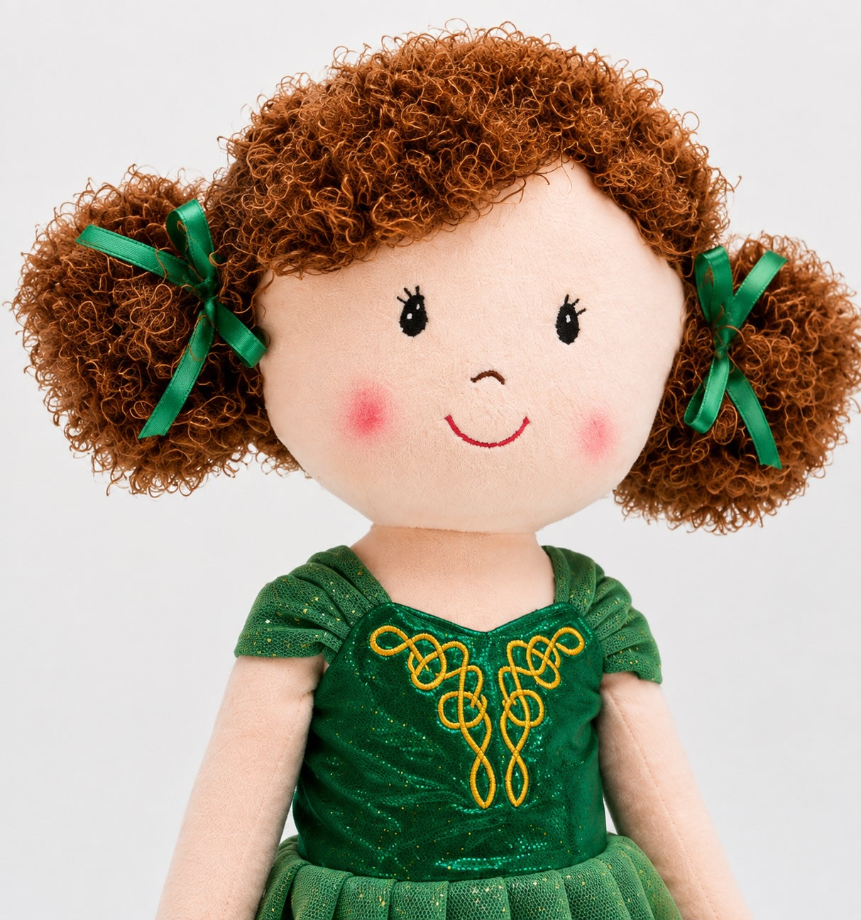 Close-up of Daydream Irish dancing doll with curly hair, green ribbons and gold Celtic dress detail