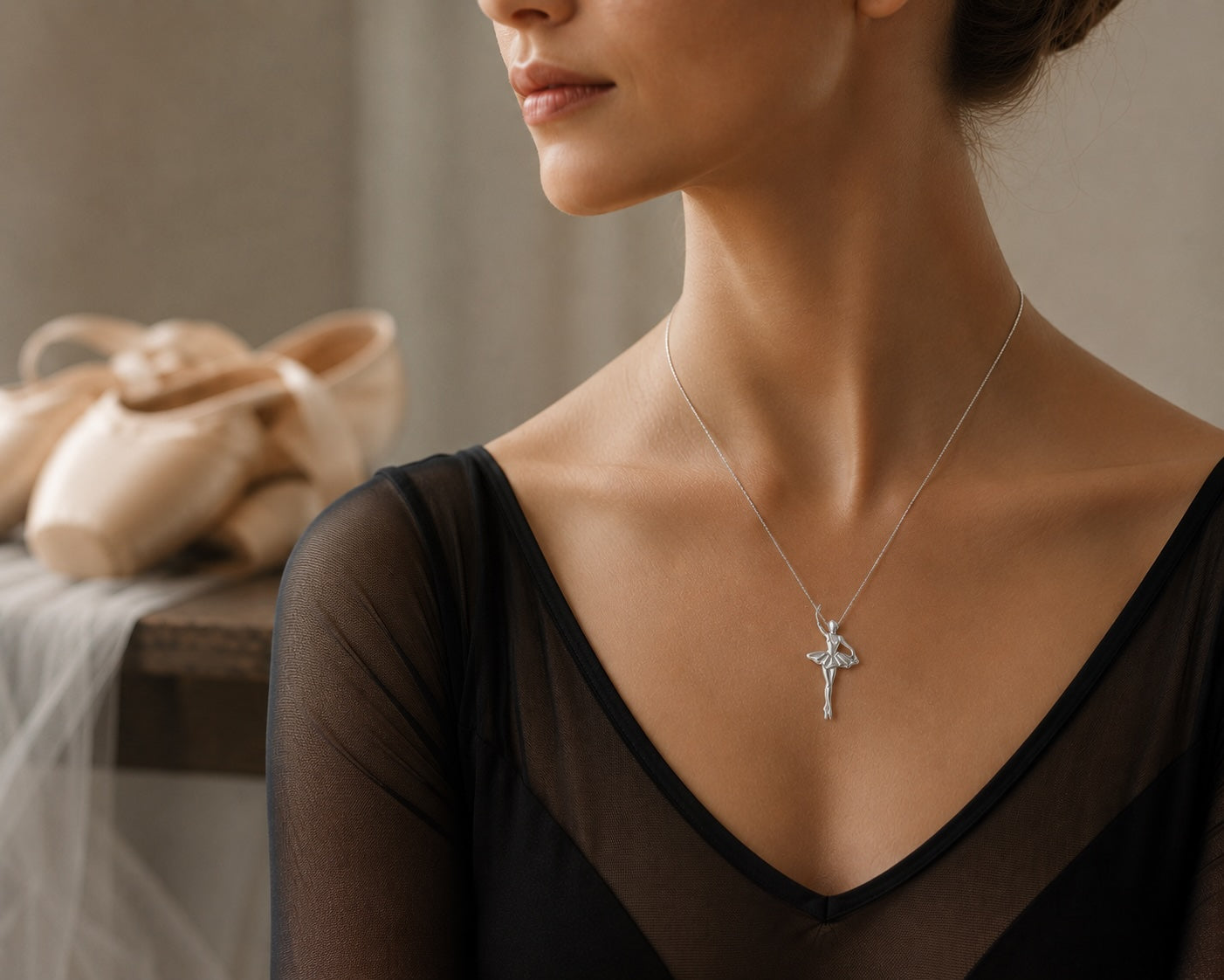 Adult ballet dancer wearing handmade Italian silver ballerina pendant necklace in ballet studio setting