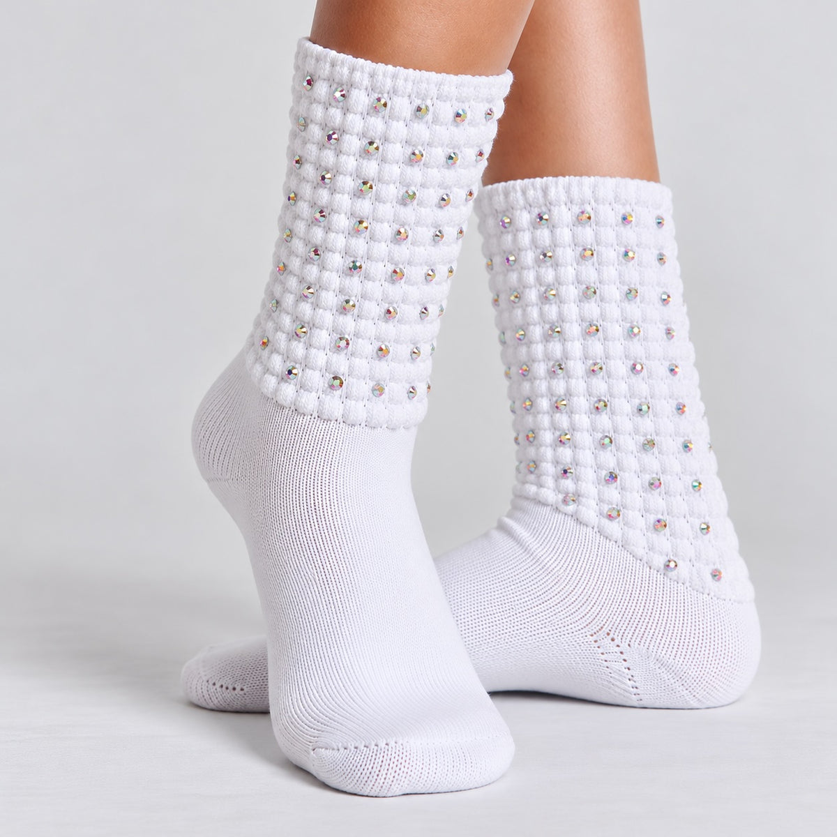 Model wearing white Irish dancing diamante poodle socks with textured bubble cuffs against a light grey background.