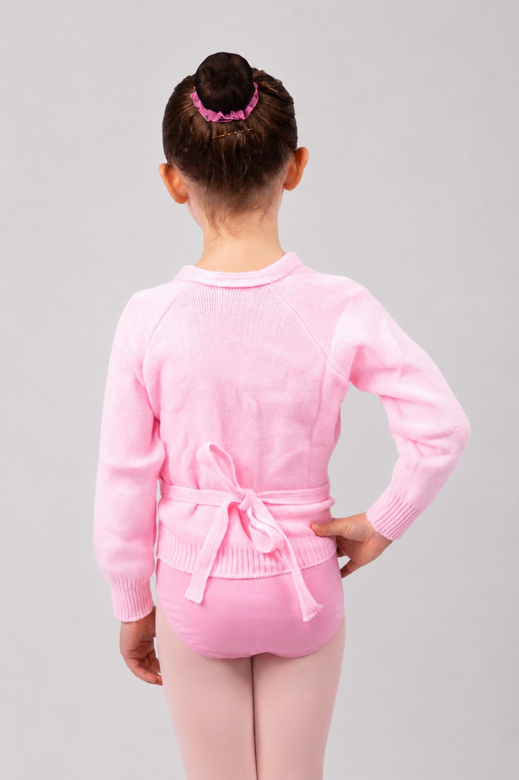 Girl wearing pink Pulsara ballet wrap cardigan – back view.