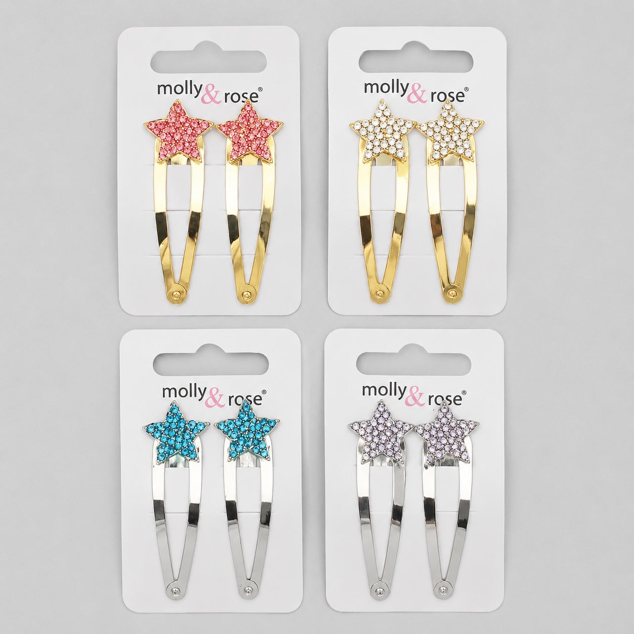 Molly & Rose sparkly star hair clips in pink, gold, blue and silver colours on a light grey background