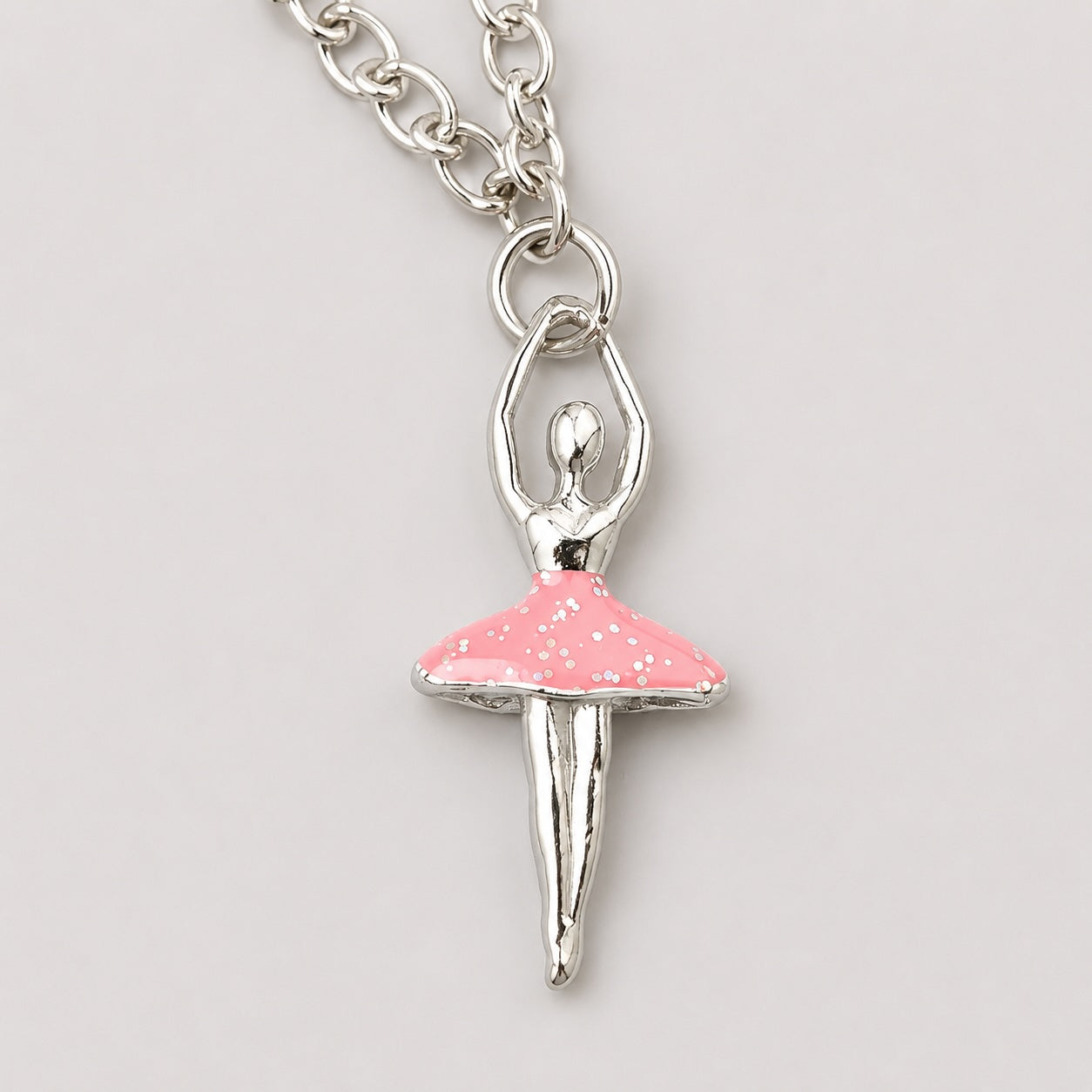 Close-up of pink ballerina charm bracelet with silver chain and glitter tutu detail for girls