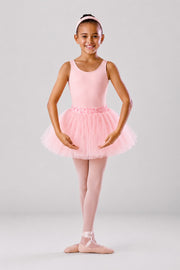 Girl wearing a pink ballet leotard and soft pink tutu skirt with ballet tights and ballet shoes on a light grey background
