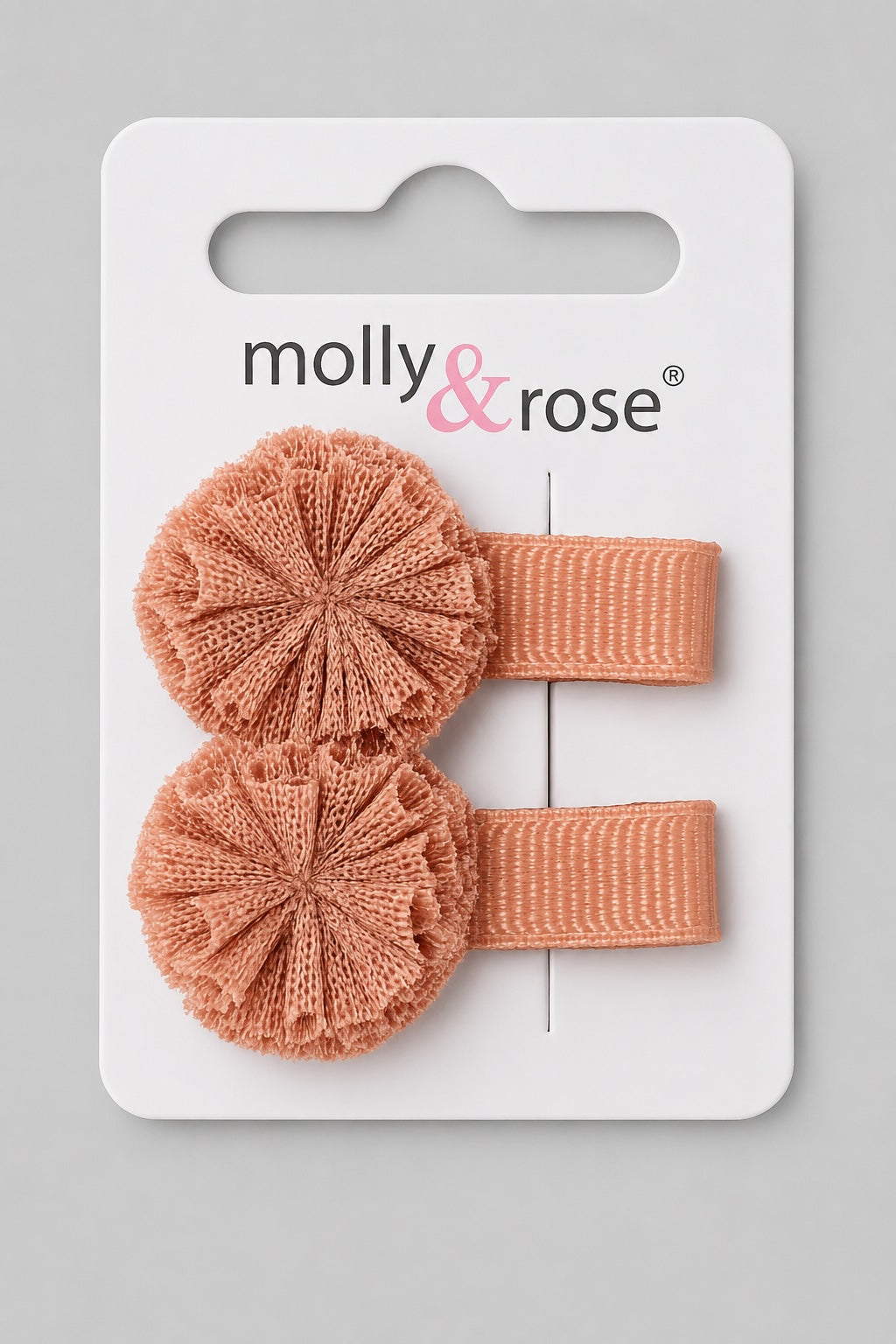 Pink pom pom hair clips on display card with grosgrain ribbon clips on a light grey background