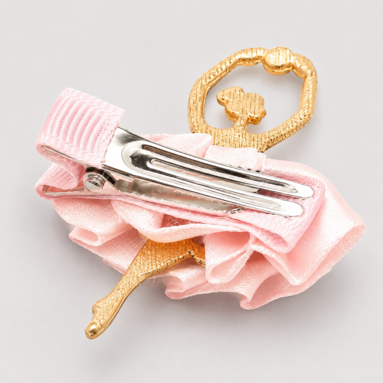 Back view detail of Molly Rose pink satin ballerina hair clip showing metal clip fastening on light grey background
