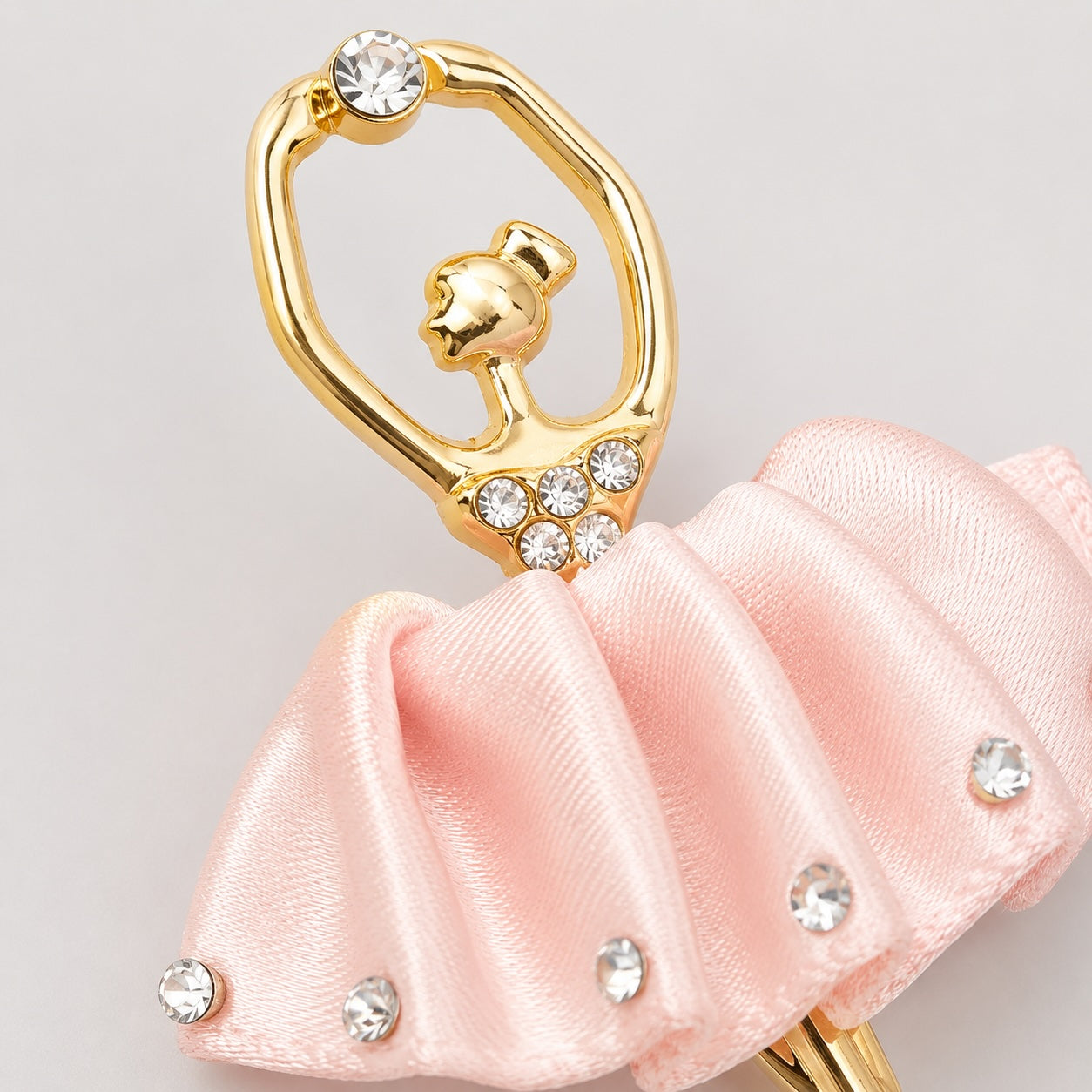 Close-up detail of Molly Rose pink satin ballerina hair clip with diamanté embellishments on light grey background