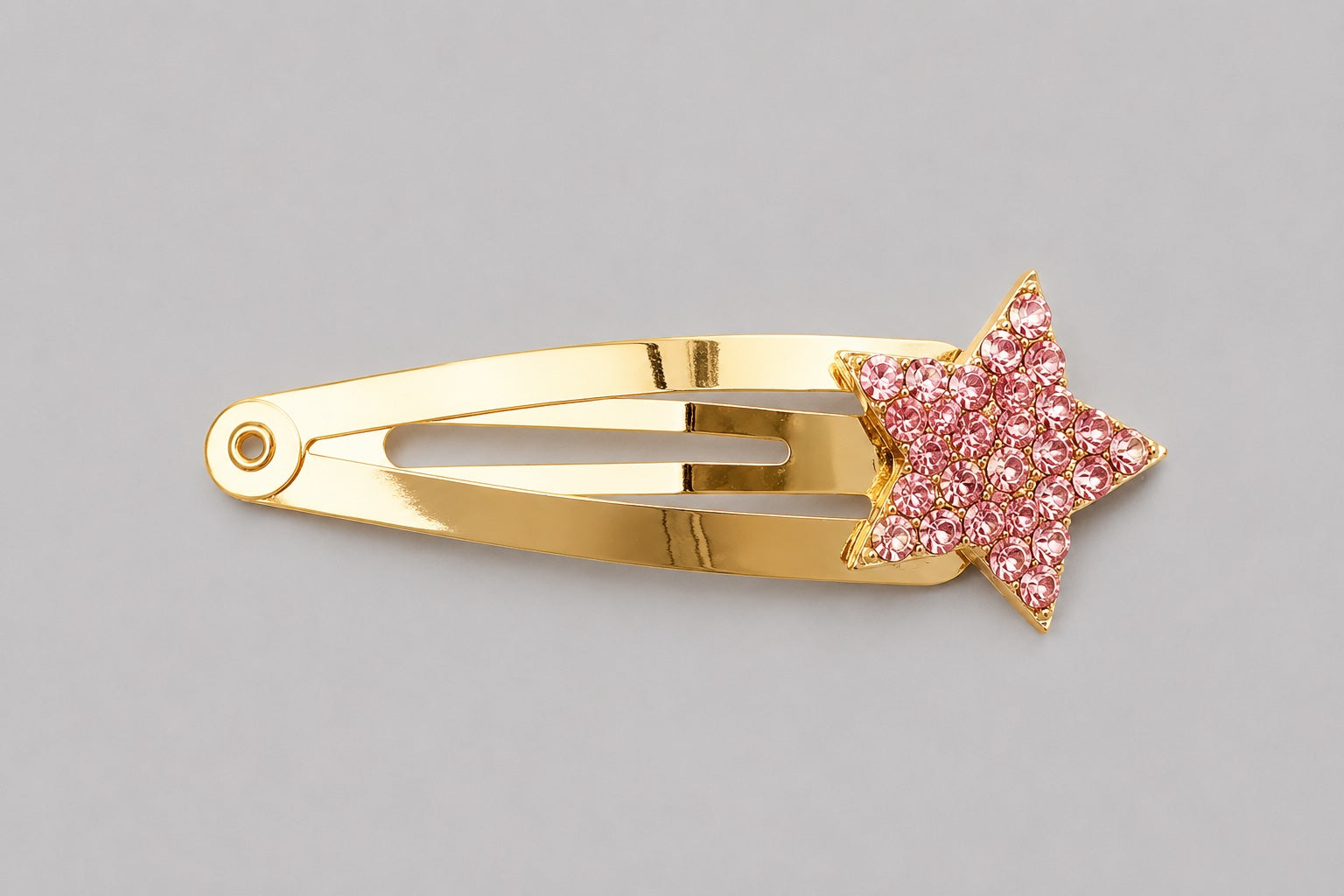 Pink sparkly star hair clip with gold clip detail on a light grey background by Molly & Rose