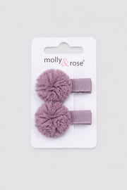 Purple pom pom hair clip with textured fabric flower on a light grey background for dancers and girls hair accessories