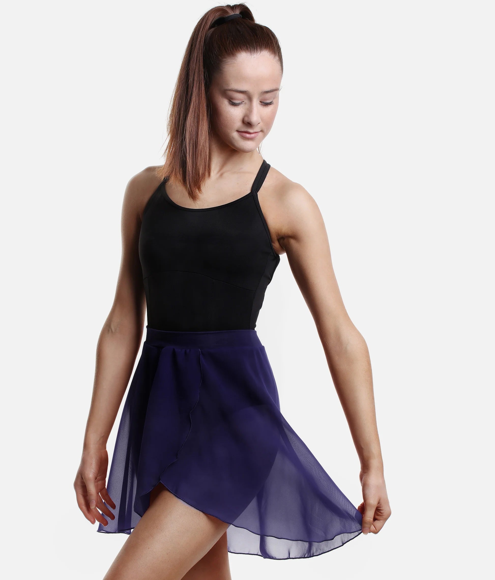 Dancer wearing navy So Danca SL93 faux wrap ballet skirt holding skirt side pose